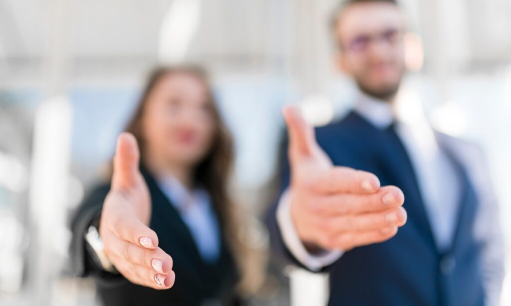 two blurred out people with their hands extended as if the viewer was supposed to shake them