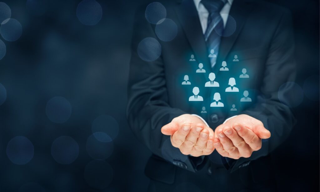 man in suit with cupped hands holding hologram of person icons