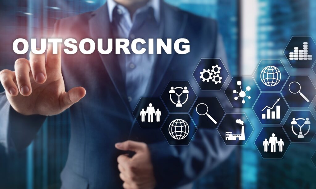 man in a suit holding his hand up and pressing the word "outsourcing" with other small images floating before him