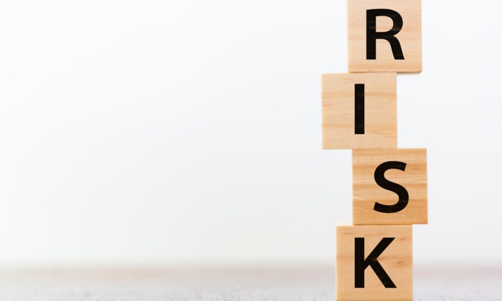 wooden blocks stacked to spell "risk"