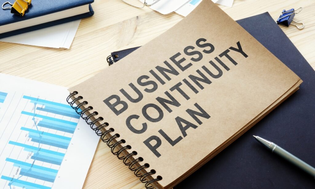 a brown notebook with "business continuity plan" written on it