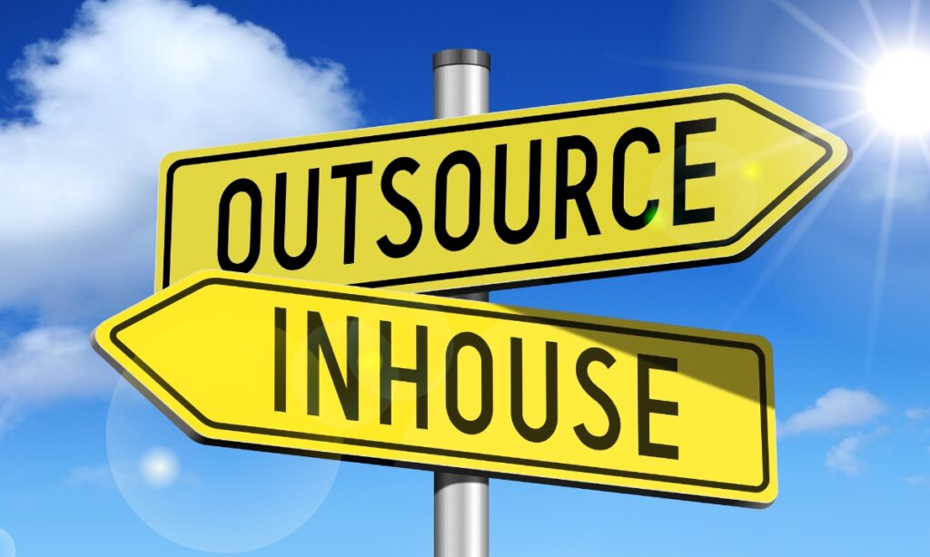 a street sign that has "outsource" pointing in one direction and "inhouse" pointing in the opposite