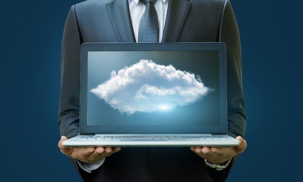 a person in a suit holding a laptop with an image of a cloud on it