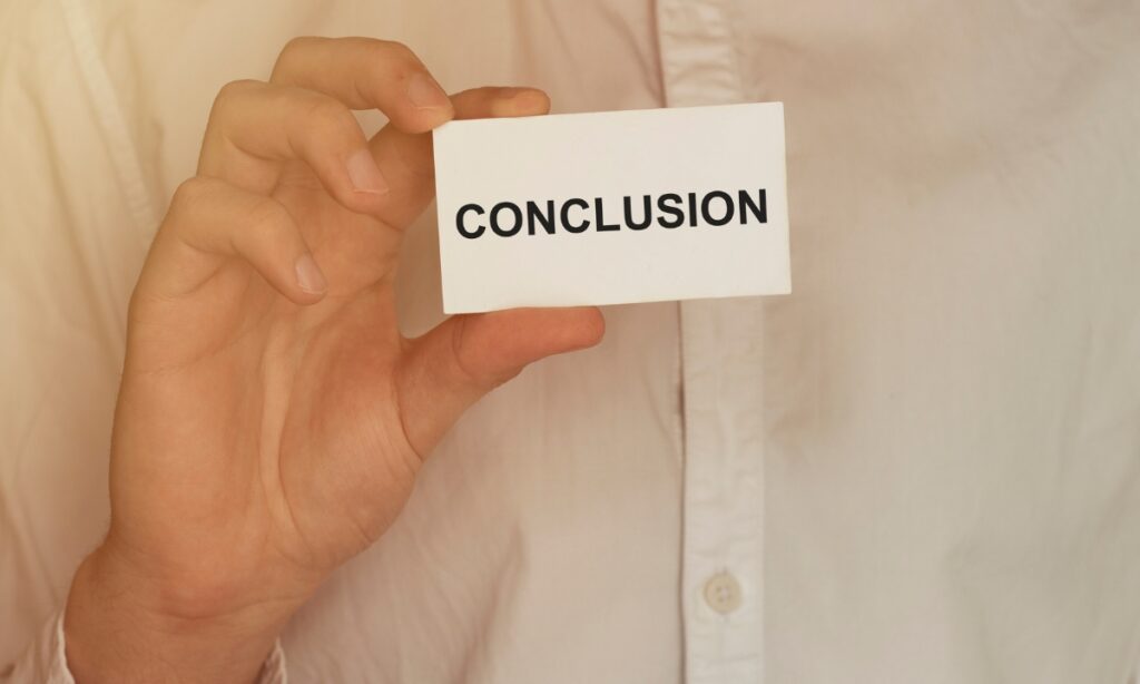 a person's hand holding a piece of paper that says "conclusion"