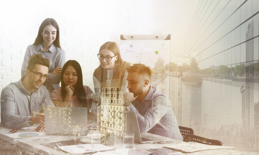 a group of people sitting at a meeting table littered with laptops and papers and there are translucent pictures of buildings in front of them