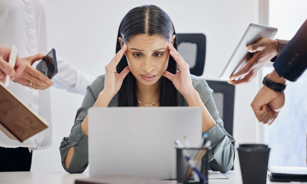 business woman who is stressed out with multiple people needing answers